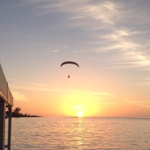view of a sunset with someone parasailing