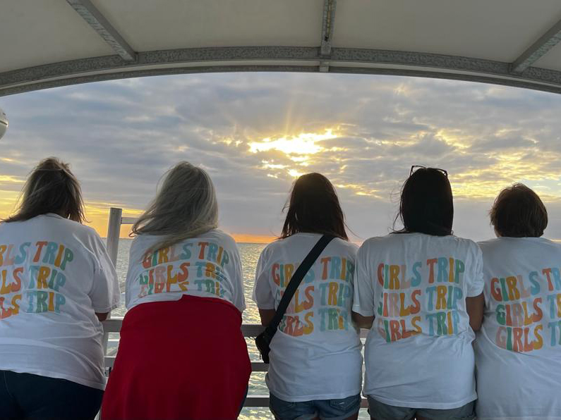 5 women on a boat wearing a girls trip shirt